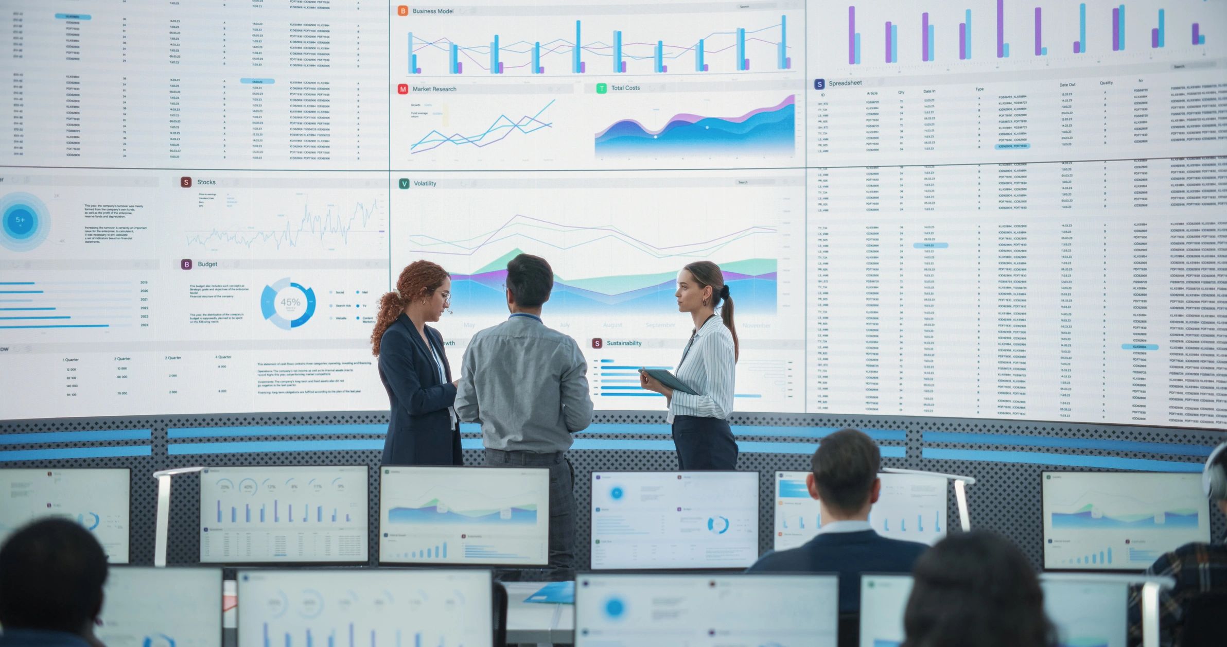 Data consulting team reviewing analytics on a large screen